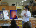 Photo of Casey Kennell teaching students pinstriping